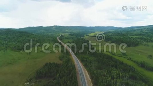 4K无人驾驶飞机射击-飞越一条道路/发现一条道路在一个美丽的森林-与汽车移动视频