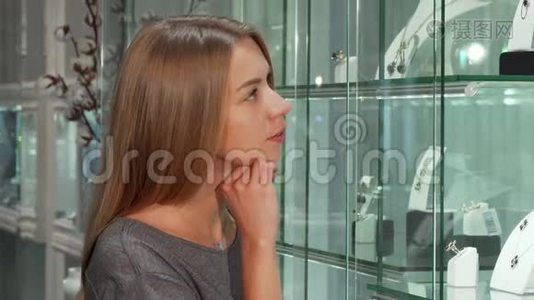 漂亮的年轻女性顾客在珠宝店检查陈列视频