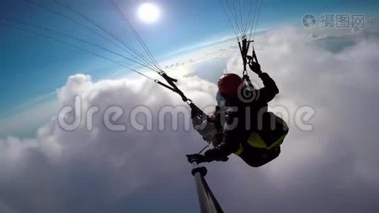 在天空、云层和天际线景观中，人滑翔伞在空中飞行。 角度自拍动作相机滑翔伞视频