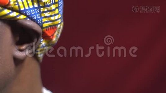 一个来自安哥拉的黑人男性，穿着传统的头饰，把脸转向相机，闭上眼睛视频