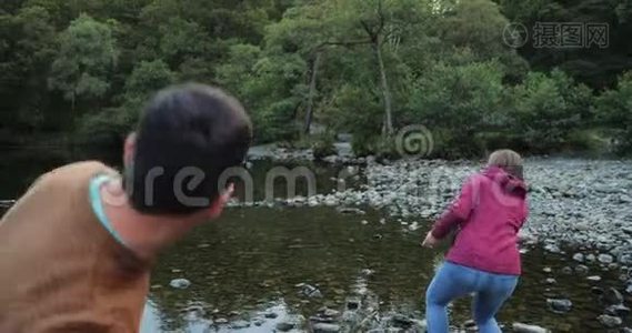 一对成熟的夫妇在湖上掠过石头视频