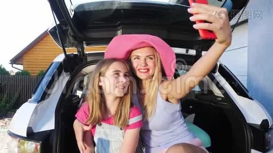 一个带着妈妈的女儿坐在车后面自拍。视频