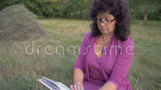中镜头，戴眼镜的老年妇女，翻开书页，体贴入微地阅读，坐在清算中视频