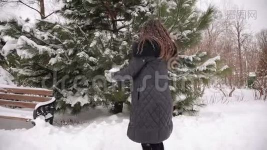 快乐的怀孕女孩在下雪的公园里撒雪视频