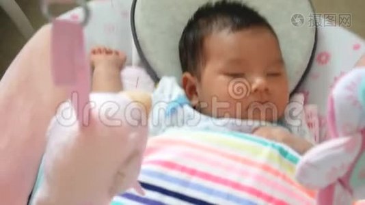 可爱的亚洲婴儿感到困倦，躺在秋千摇篮里视频