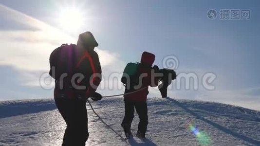 三个登山队员在雪山上爬绳.. 旅游者一起工作，集体摇身一变，克服困难视频