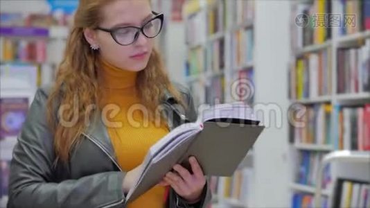 肖像特写幸福美丽的年轻女子，戴眼镜的女孩在书库大学读书视频
