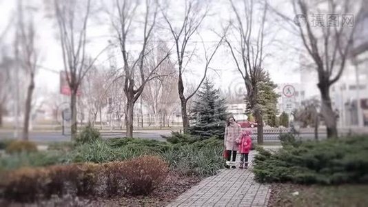 一个带着妈妈的小女孩在冬天的城市里散步时兴高采烈地说着视频