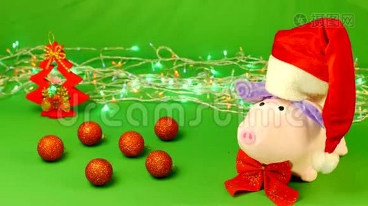 戴着圣诞老人帽子的软玩具猪站在一个装饰物上，圣诞节，慢动作视频