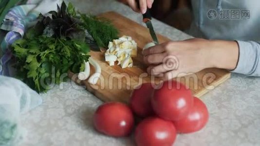 在木板上用刀切煮鸡蛋，把女人的手收起来。 食物概念视频