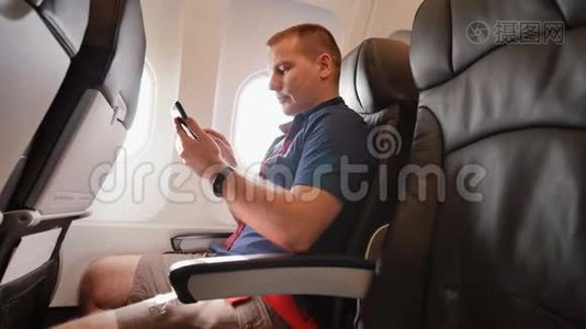 飞机上的年轻人在飞行前用手机交流。视频