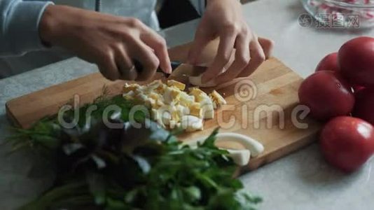 在木板上用刀切煮鸡蛋，把女人的手收起来。 食物概念视频