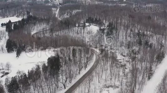 冬天，空中拍摄一条弯曲的僻静道路。视频