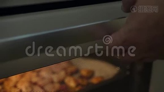 用烤土豆煮开烤箱门。 健康素食饮食或烹饪食谱概念4K页。视频