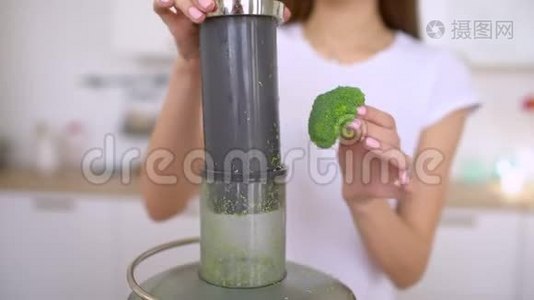 榨汁机制作绿色花椰菜蔬菜汁.. 关闭榨汁机和女人手把蔬菜放入果汁中视频