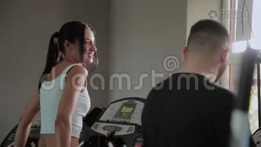 美丽的运动女性和超重的男性正在跑步机上训练。视频