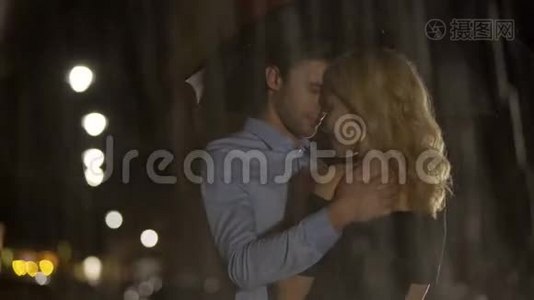 男人在雨中抚摸他的金发女朋友，一对等待出租车的夫妇，爱视频