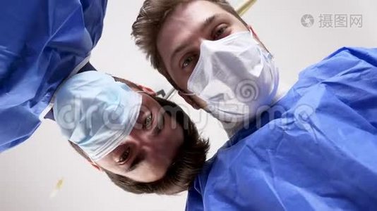 两名外科医生在手术成功后正在检查一名病人并握手视频