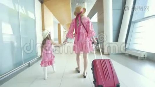 母亲和小女儿牵着手走到机场候车室后景视频