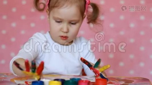 小女孩用刷子和油漆画画。 宝贝艺术。 古奇和油漆视频