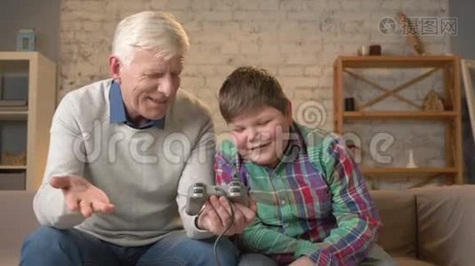 孙子教爷爷玩控制台游戏.. 老人正在学习如何玩电子游戏，他没有视频