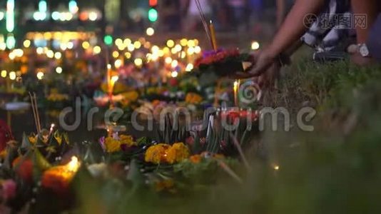人们个人把一支燃烧着的蜡烛放在满是漂浮充满漂浮的克拉通的水中。 庆祝泰国传统节日视频