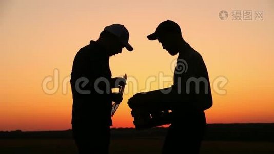 两个农民在日落时交谈。 在夕阳下看着番茄。 侧视图视频