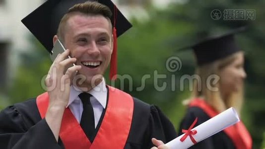 快乐的男同学打电话，收到毕业的祝贺视频
