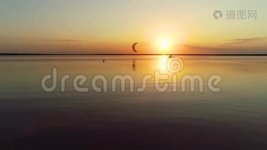 在湖边欣赏日落的全景，在那里一个人在风筝上航行到一边视频