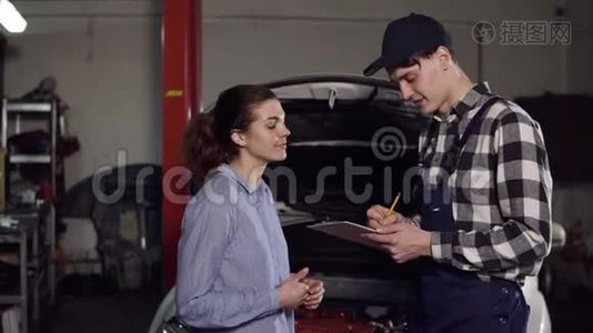 年轻有魅力的女车主向汽车技师解释了她对自己车辆的抱怨和签名视频