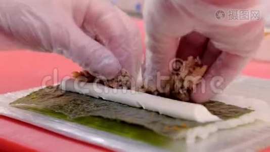 厨师用鱼乳奶酪和诺丽做卷，制作卷的过程，食谱。手特写。视频