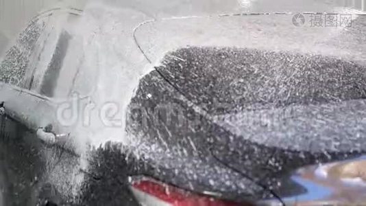 在汽车上涂上泡沫。 为汽车做化学实验。 把车洗干净。视频