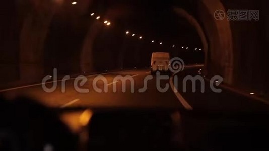 沿着一条灯光明亮的汽车隧道，跟着一辆白色卡车，在一条山道上行驶，景色令人叹为观止视频