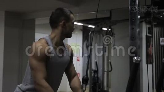 健身者的肖像，他正在健身房里拉体重设备。视频