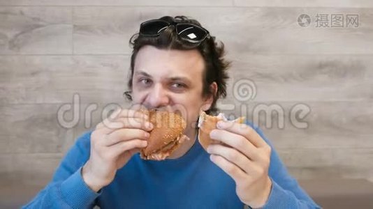 人们一边吃汉堡包，一边坐在咖啡馆里。视频