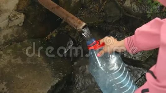 女人`手把天然泉水倒进瓶子里。视频