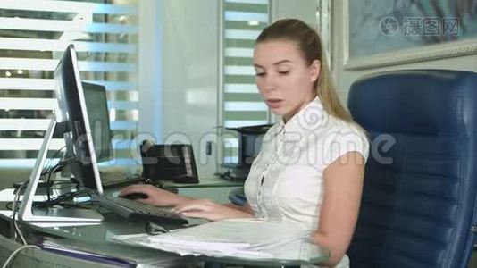 一个疲惫而困倦的年轻商务女性拿着笔记本电脑坐在办公桌前视频