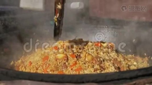 在户外的金属锅中烹制国家亚洲米菜。 在火上做饭。 火上的鱼汤。 大锅里的食物视频