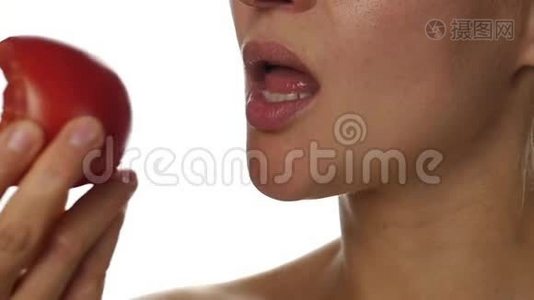 美女嘴吃番茄。 喜欢品尝西红柿的女孩。 健康的食物和节食的概念。 慢动作视频