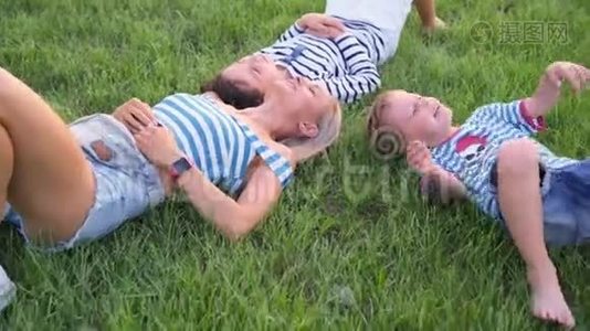 家庭生活方式的场景，母亲和儿子一起在公园的绿草上休息。视频