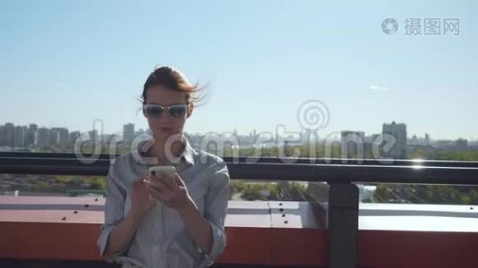 年轻商务女性在阳台上发短信。视频