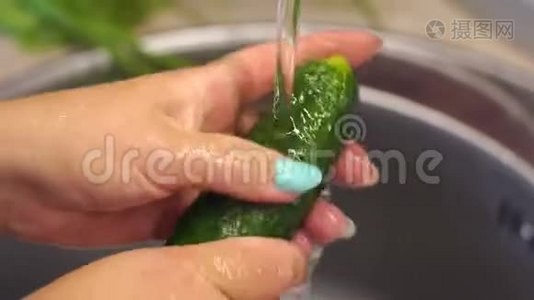 一个女人在厨房水槽里洗新鲜黄瓜的特写镜头。 慢动作。视频