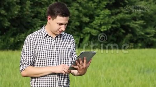 白种人的黑黑肤色的农民在田里用平板电脑工作。 在农业领域工作的科学家视频
