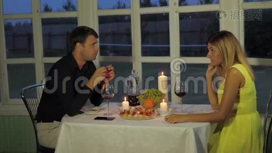 夜晚的一对情侣在阳台上放着浪漫的烛光，有趣的谈话视频