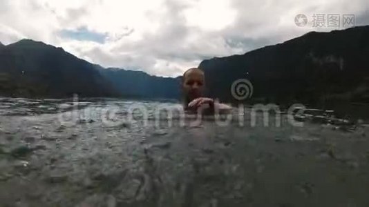 把水溅到摄像机上。 微笑的男孩慢动作。 美丽的山湖视频