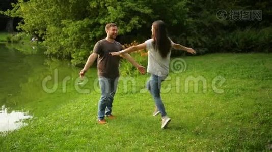 健康强壮的男朋友在市立公园拥抱并在户外旋转他的女朋友。可爱的一对享受夏天视频