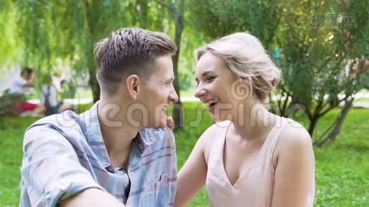 年轻的新婚夫妇坐在绿色公园里，关系愉快，慢悠悠视频