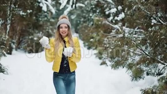 可爱的女孩在森林里玩雪球。活跃的年轻女子在镜头前玩雪球视频