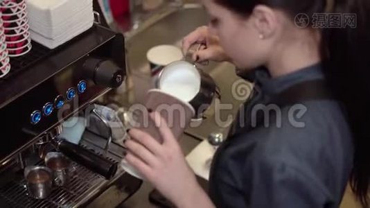 女咖啡师准备将牛奶倒入纸杯中，加入咖啡，并在牛奶上画在牛奶上视频