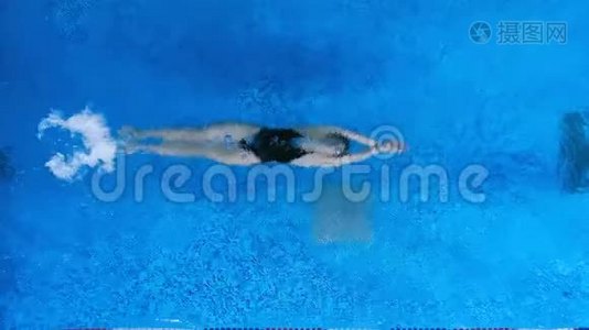 一个游泳者在她的背部水下移动，然后向上移动。视频